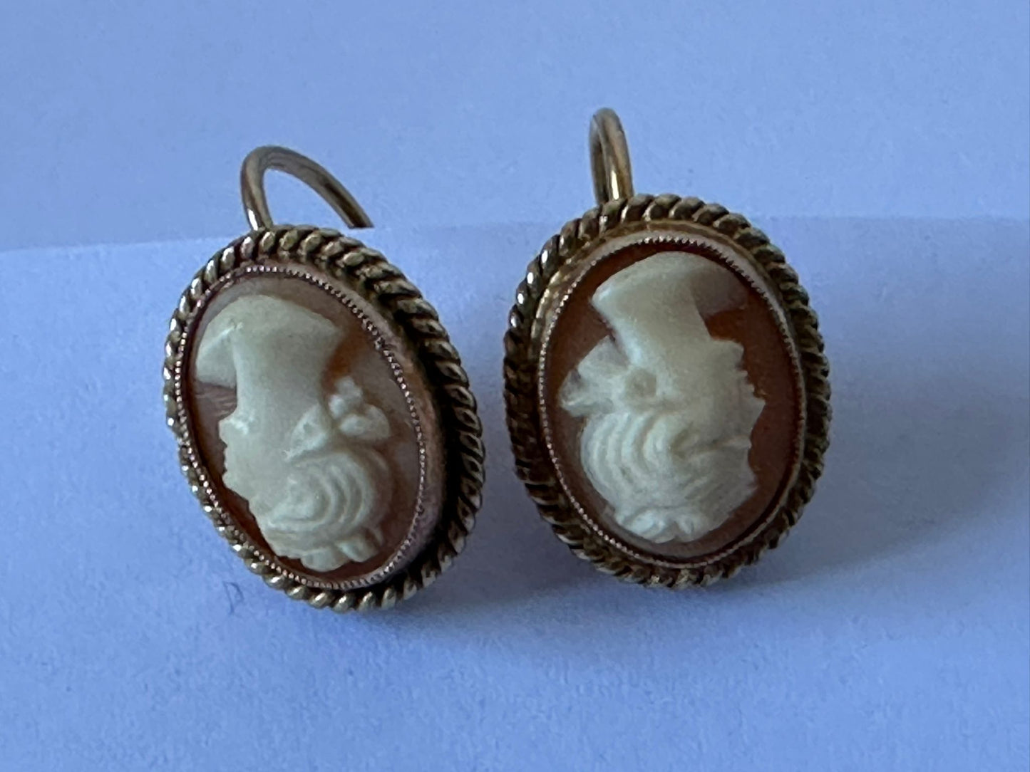 Antique shell cameo earrings with finely carved profiles, set in gold.