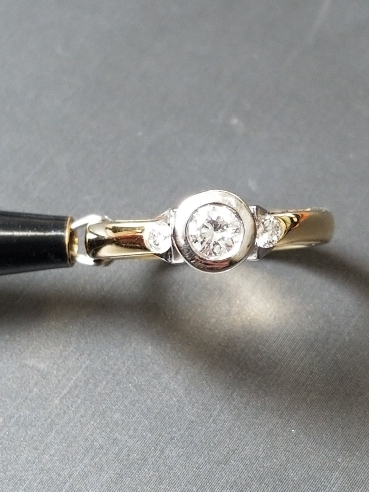 Close-up of the natural diamond bezel setting on the trilogy ring