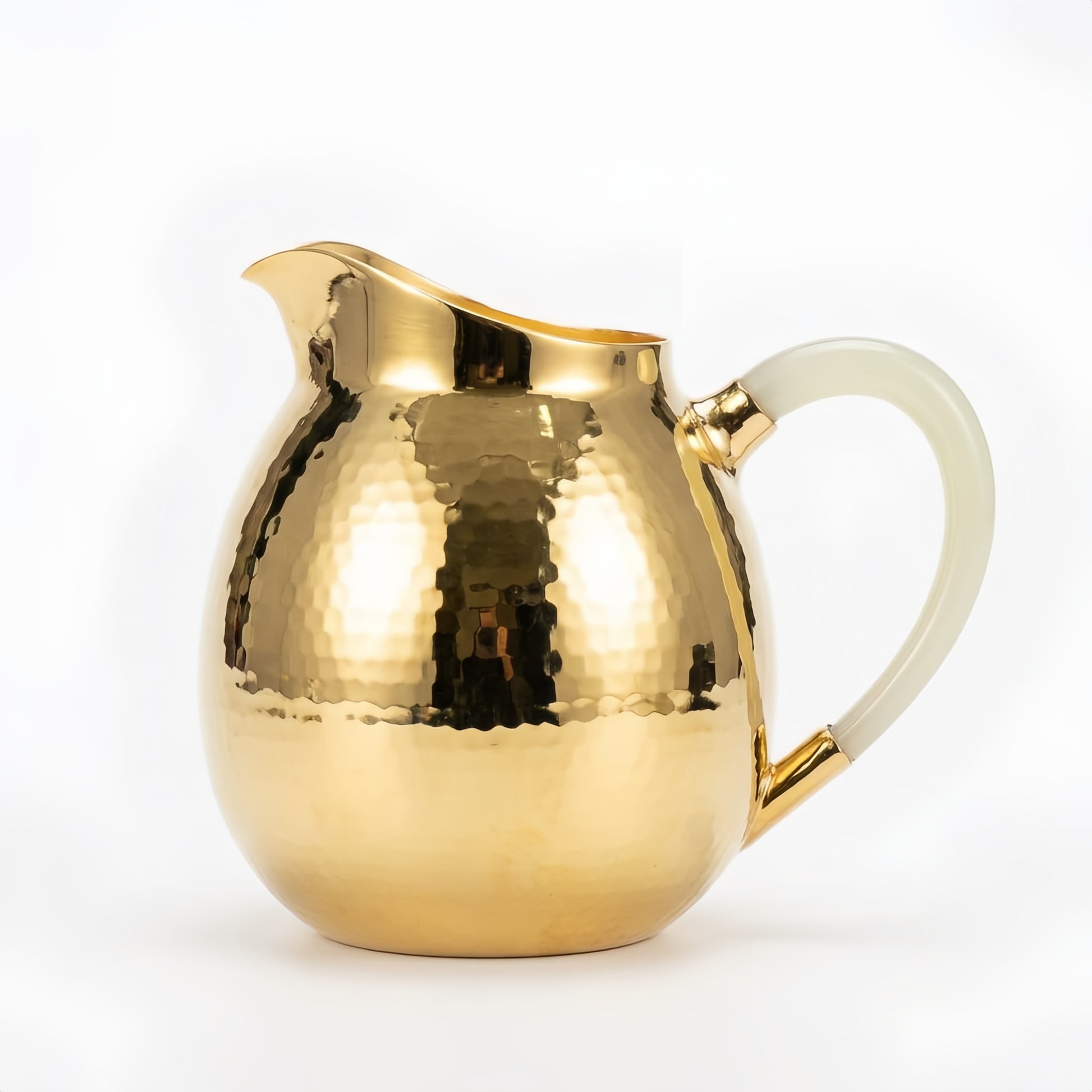 Hammered silver-tone serving pitcher with curved spout and creamy white handle