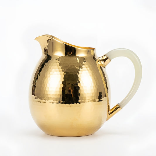 Hammered silver-tone serving pitcher with curved spout and creamy white handle