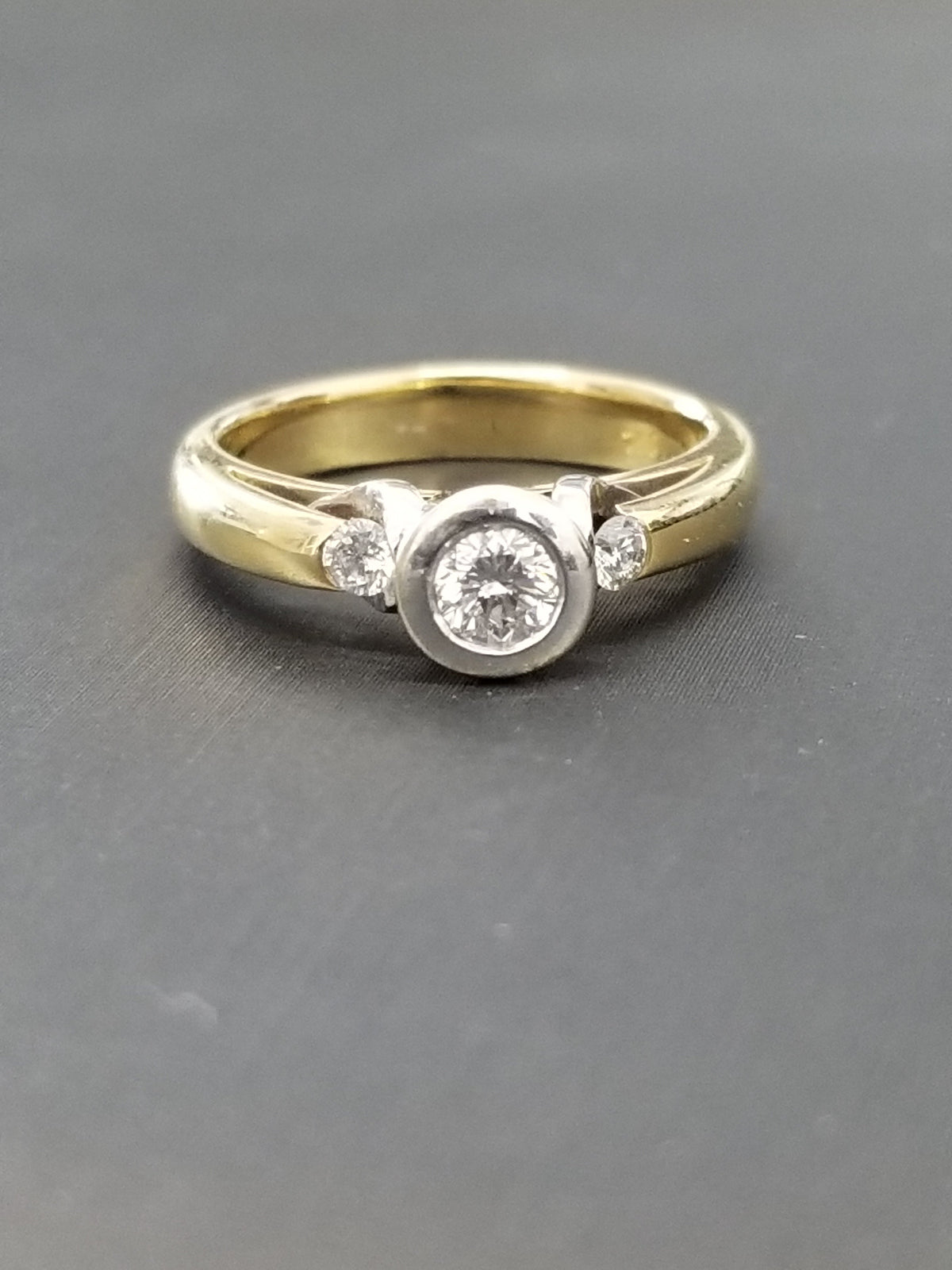 Natural Diamond Bezel Trilogy ring - 18ct yellow gold band with white gold bezel setting, front view